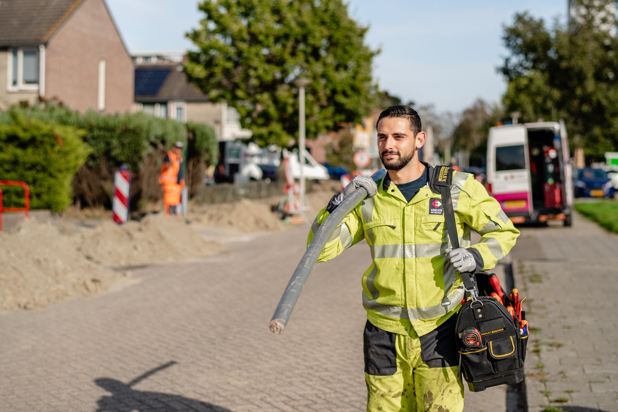 Een monteur die een kabel aan het dragen is