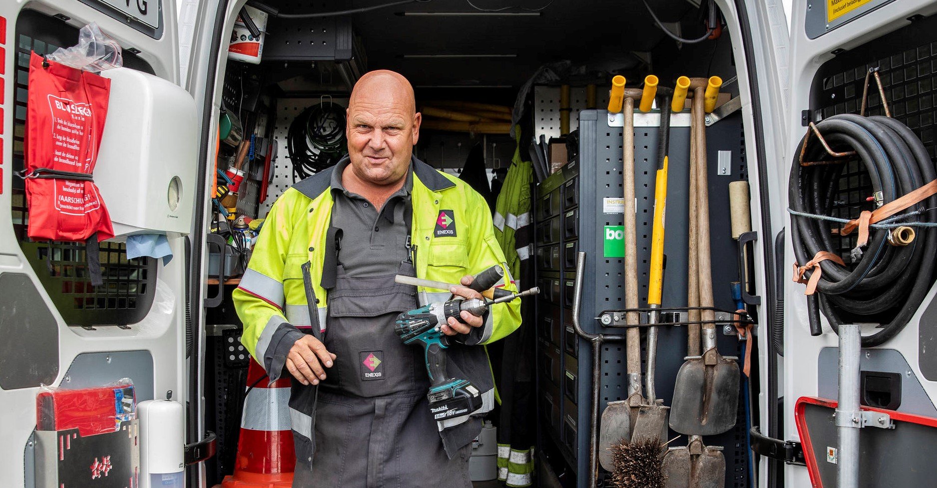 Monteur stapt met gereedschap uit werkbus