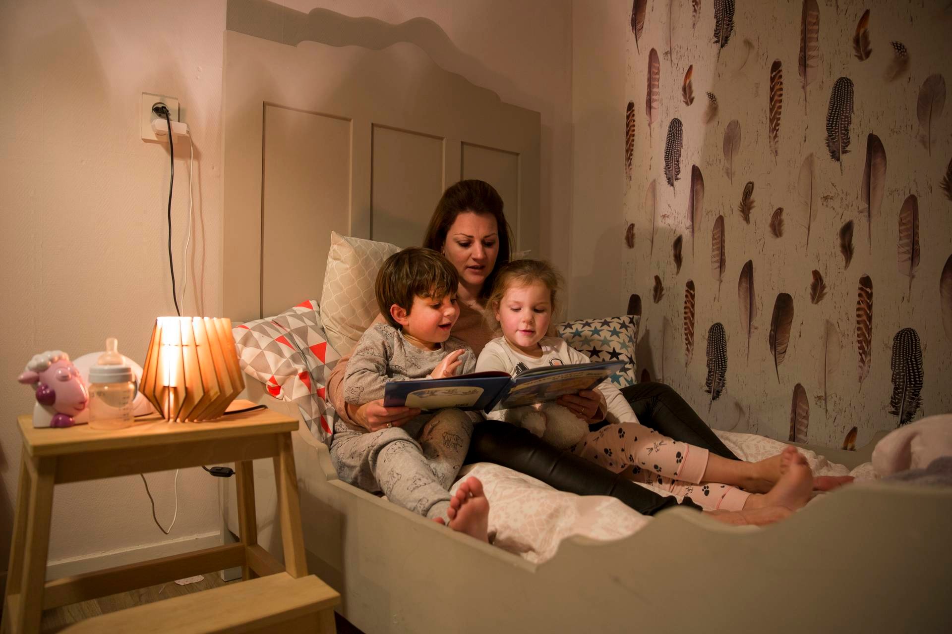 Moeder met kinderen voorlezen in bed