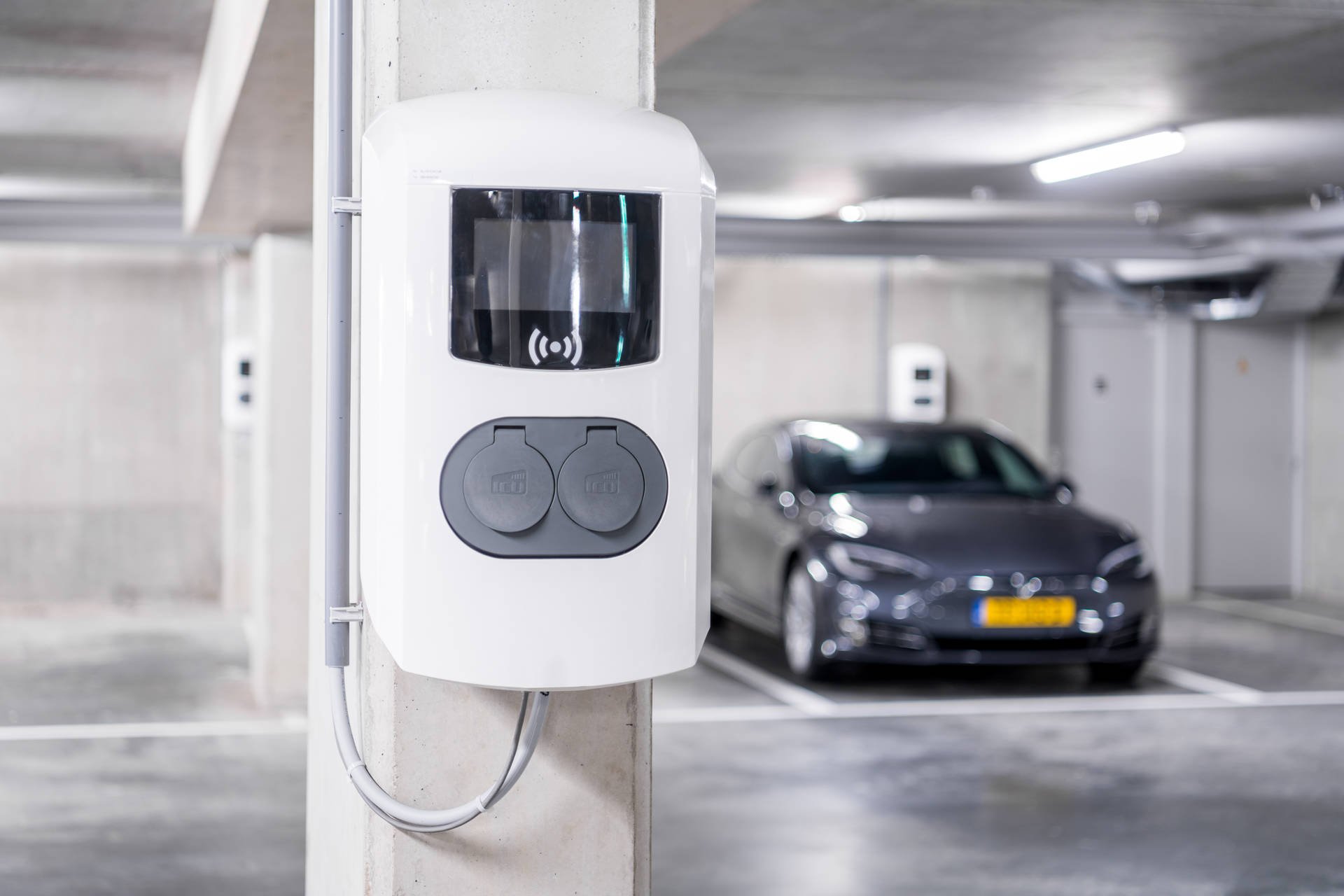 Lader elektrische auto met elektrische auto op de achtergrond