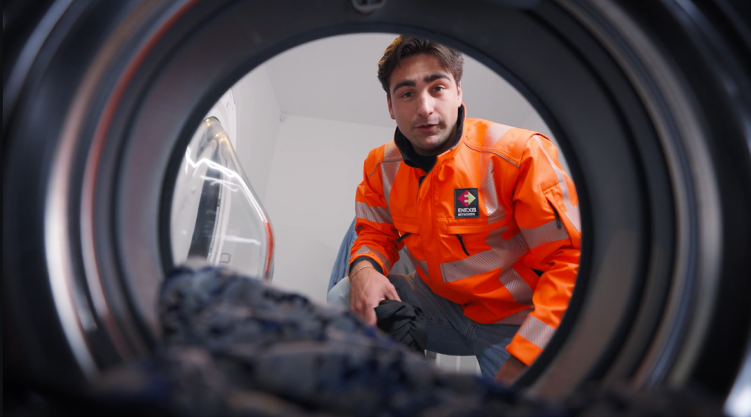 Monteur van Enexis in beeld vanuit trommel wasmachine