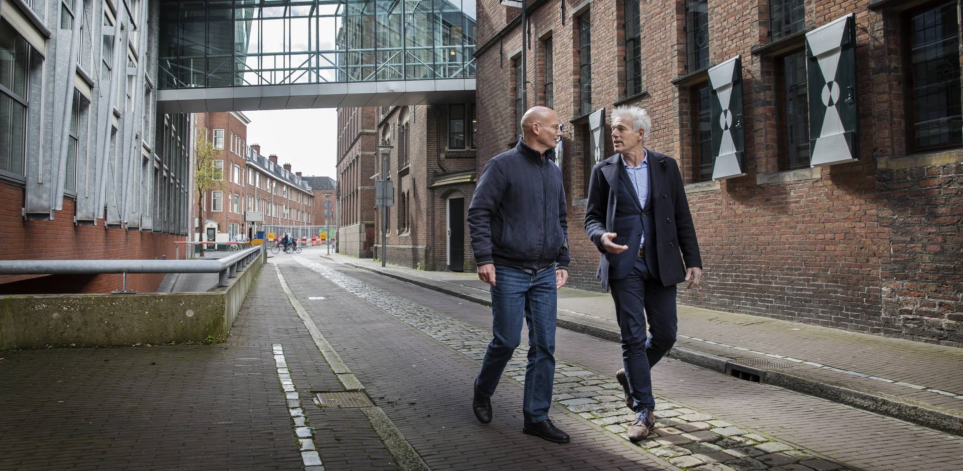 Gemeentehuis met daarvoor twee mannen die met elkaar praten