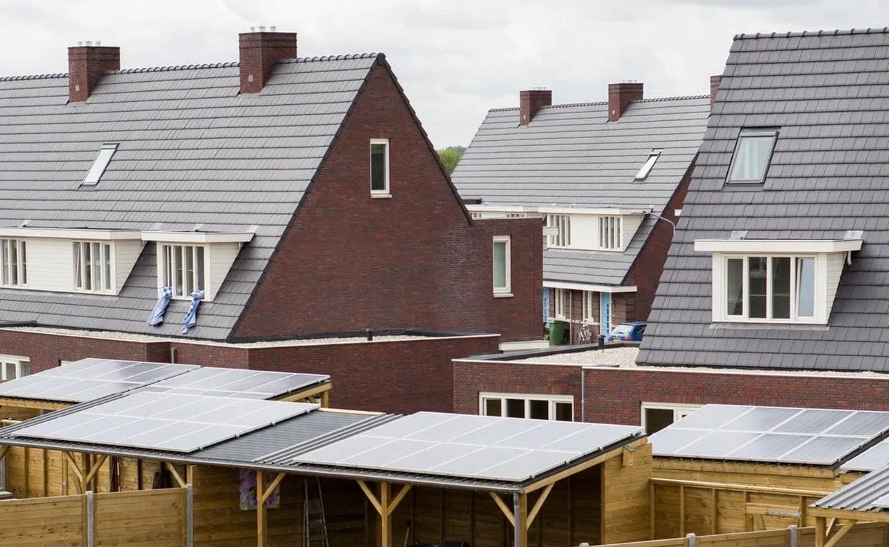 Woningen met zonnepanelen op daken van schuurjes