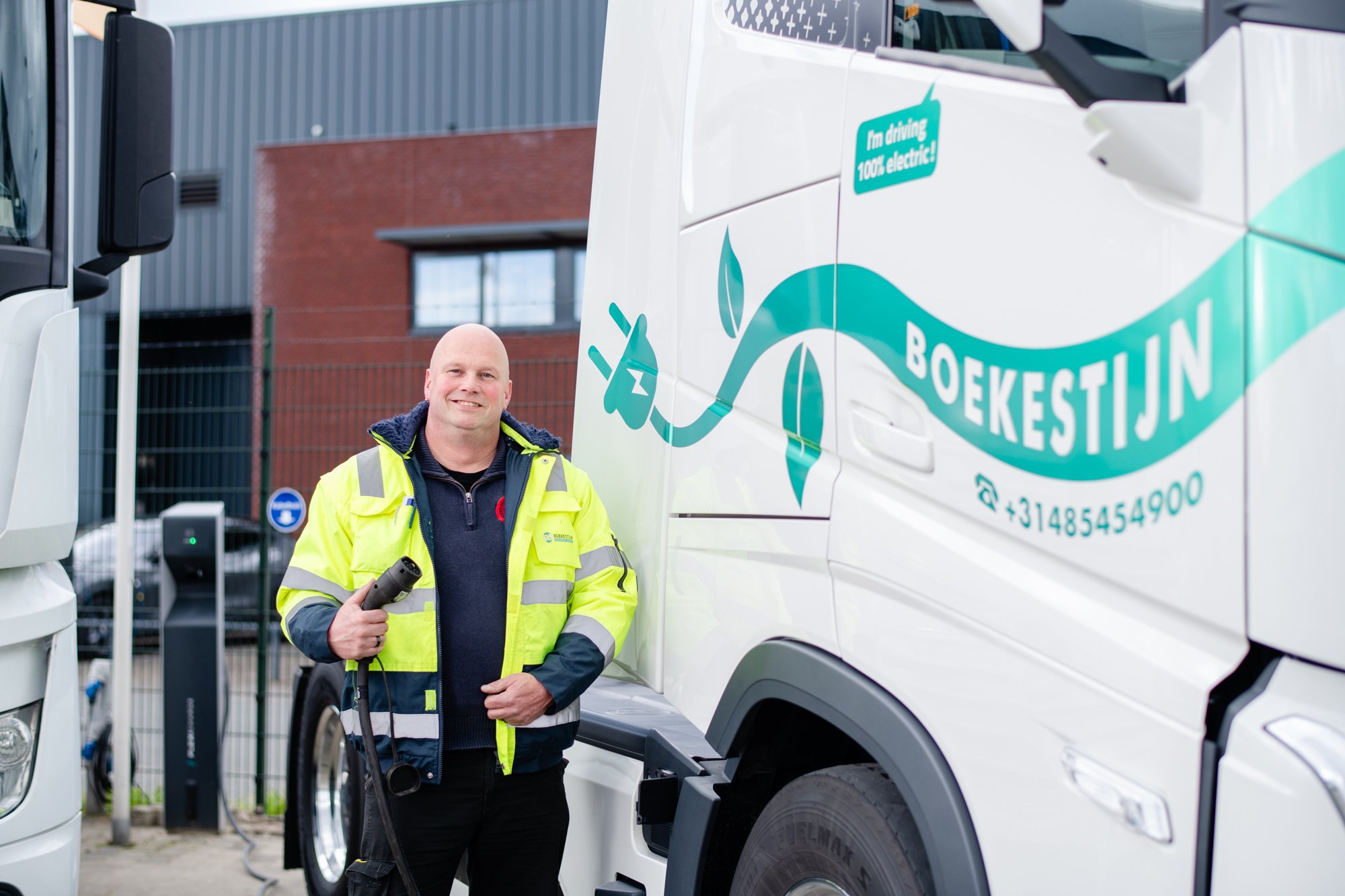 Medewerker Boekestijn Transport met laadkabel in zijn hand